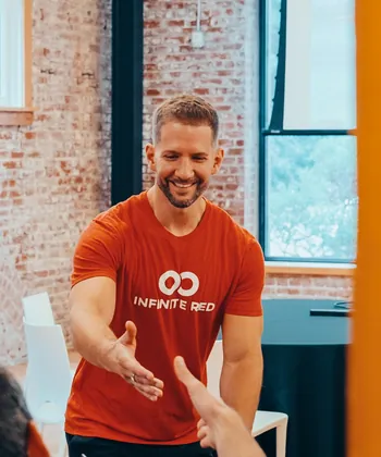 A smiling conference attendee reaching across a table.
